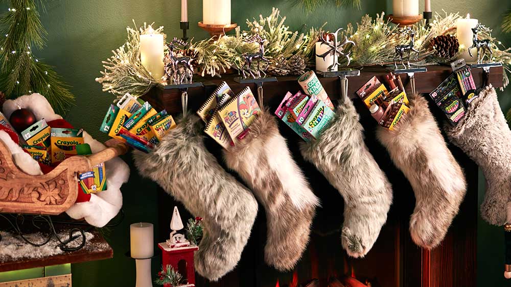 Stockings on mantal stuffed with Crayola gifts.